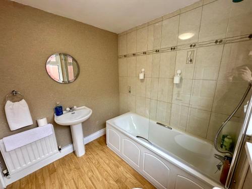 a bathroom with a sink and a bath tub and a sink at 2br Ormeau central in Belfast