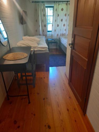 a room with a table and a bed and a door at Wiikki Majatalo in Viitasaari