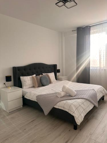 a bedroom with a large bed with a black headboard at Apartament Urban Chic in Sebeş