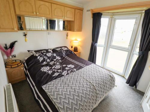 a bedroom with a bed and a large window at Towervans Z11 in Mablethorpe