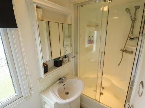 a white bathroom with a shower and a sink at Towervans Z11 in Mablethorpe