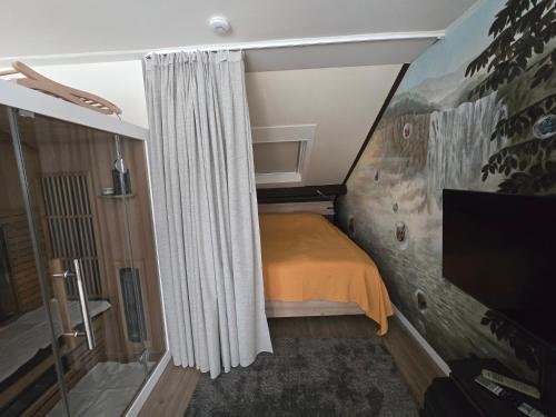 a small bedroom with a bed and a curtain at Studio Amnesia in Heerhugowaard