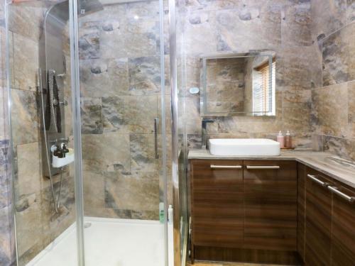 a bathroom with a shower and a sink at 36 Cae Rhos in Holyhead
