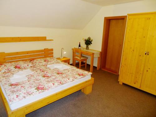 a bedroom with a bed and a table and a desk at Penzion Bystrinka in Tale