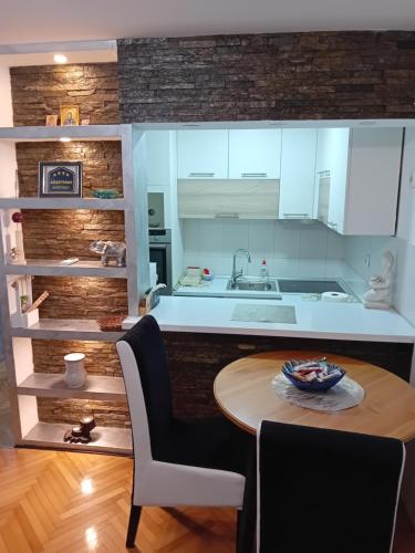 a kitchen with a table and a kitchen with white cabinets at Dimitra Stan na dan in Šabac