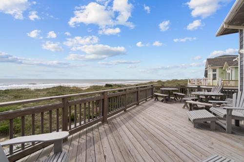 a deck with picnic tables and benches and the beach at 7865 - Peridot in Frisco