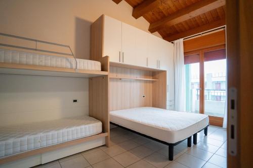 a bedroom with two bunk beds and a window at Residence Roberta - Agenzia Arcobaleno in Caorle
