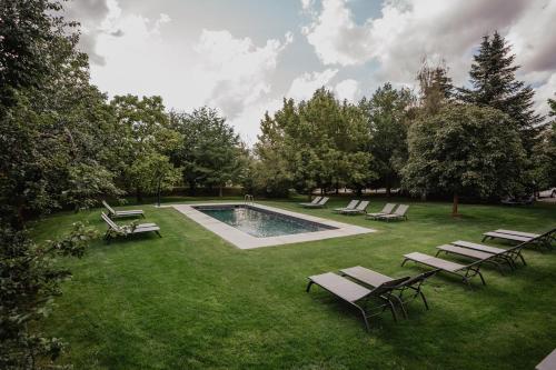 a group of chairs and a pool in the grass at Hotel Bernat de So in Llivia