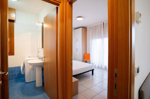 a bathroom with a sink and a bed in a room at Residence Roberta - Agenzia Arcobaleno in Caorle