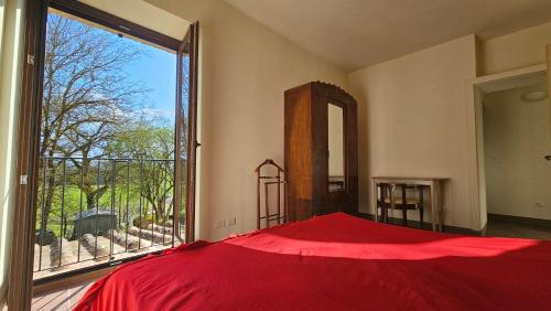 a bedroom with a red bed and a large window at Da Taz Siena in Siena