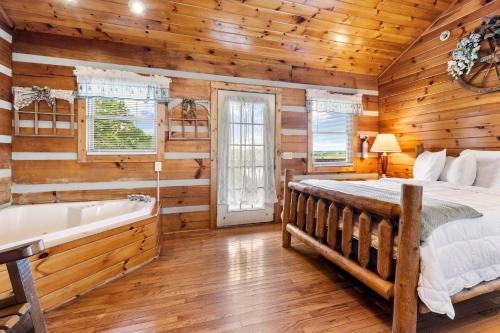 a log cabin bedroom with a bed and a bathtub at Hillside Hideout Log Cabin For 2! Cabin 10 in Fancy Gap