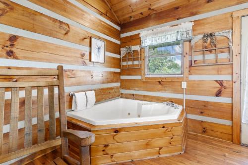 a bathroom with a tub in a log cabin at Hillside Hideout Log Cabin For 2! Cabin 10 in Fancy Gap