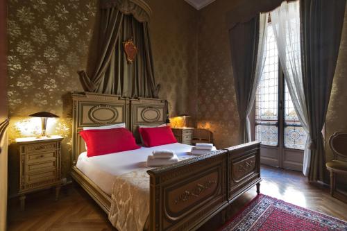 a bedroom with a large bed with red pillows at Casa della Contessa Art Guest House in Turin