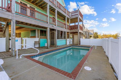a house with a swimming pool in the backyard at 7200 - Better Surf Than Sorry in Salvo