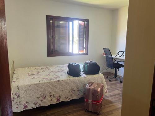 a bedroom with a bed with two bags on it at Comfortable home, close to everything! in Caçapava do Sul