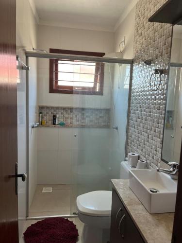 a bathroom with a shower and a toilet and a sink at Comfortable home, close to everything! in Caçapava do Sul