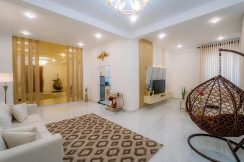 a living room with a white couch and a chandelier at Peak Heaven Apartments in Negombo