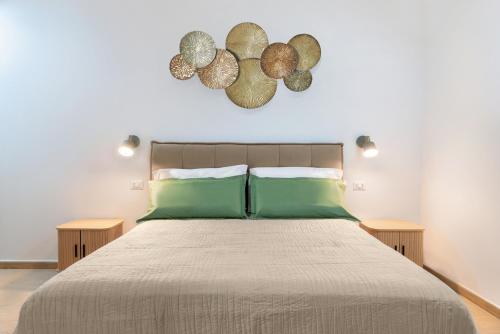 a bedroom with a large bed with green pillows at Terra e Mare Apartments II- Terra in Sorso
