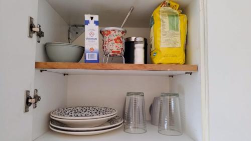 a cupboard with dishes and other kitchen items on it at Depto B in Rincon de los Sauces