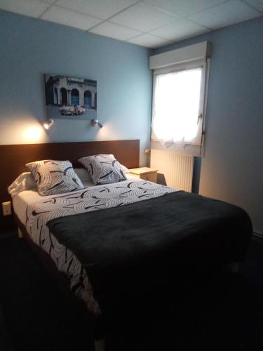 a bedroom with a large bed with a window at Hôtel Bon Repos in Barbezieux-Saint-Hilaire