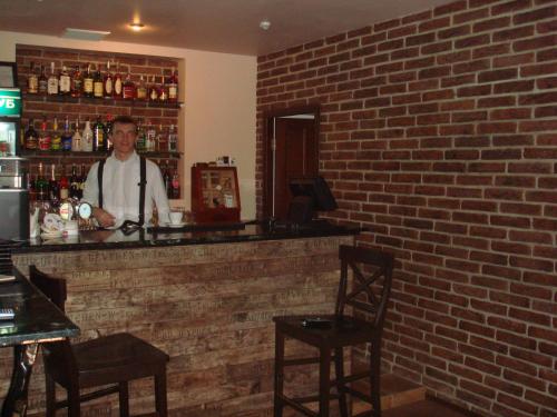 a man standing behind a bar in a brick wall at Status Hotel in Poltava