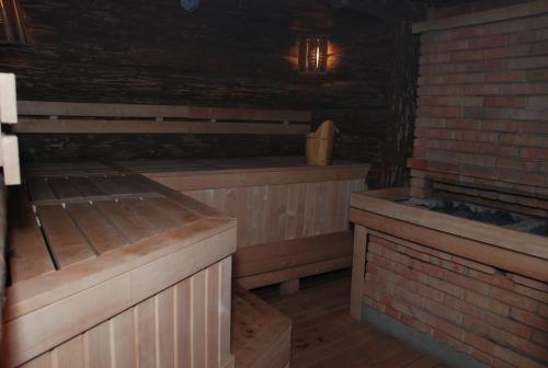 a room with two wooden benches and a brick wall at Status Hotel in Poltava
