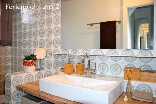 a bathroom with a white sink and a mirror at Ferienwohnung Janssen Herborn in Herborn