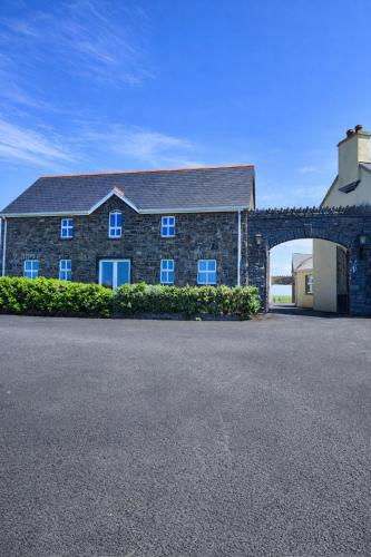 a large brick building with a large garage at Aran View Holiday Homes Doolin - The Atlantic Stone House - Ocean Views in Doolin