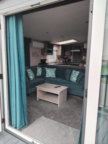 a living room with a couch and a coffee table at Thrillseeker - Chalet style caravan next to Fantasy Island, Ingoldmells, 2 dogs max - East Coast Holidays in Skegness