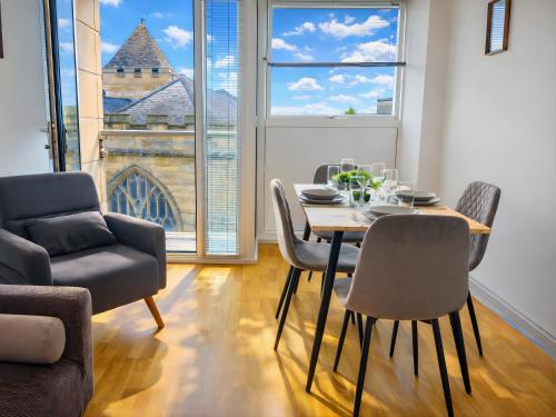 a dining room with a table and chairs and a window at York City Centre 2 bed Flat with Disable Access 2 bath - Balcony and City View in York