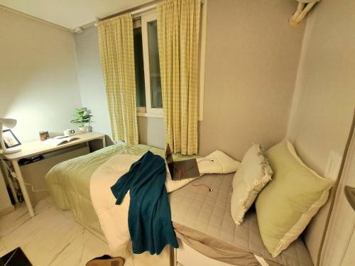 a bedroom with a bed and a desk and a window at Dodahm guesthouse stay in Incheon
