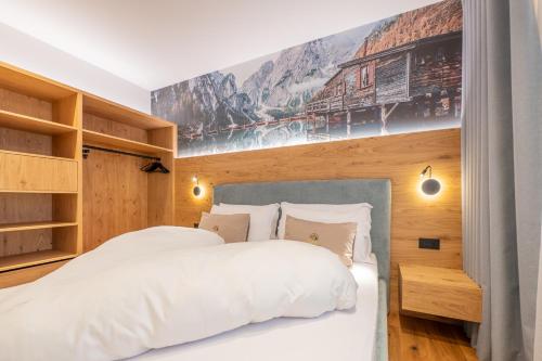 a bedroom with two beds and a poster on the wall at Appartament Lago di Braies in San Sigismondo