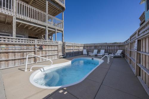 a hot tub on the patio of a building at 7158 - A Wave From It All in Waves
