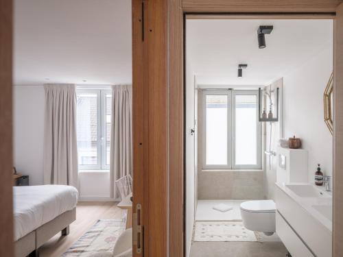 a white bathroom with a toilet and a sink at Suzan's Guesthouse in Ghent