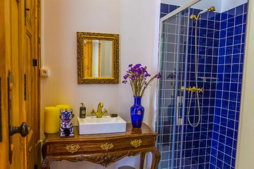 a bathroom with a sink and a blue tiled shower at Porto Alegria Garden in Porto