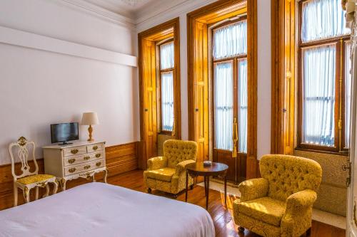 ポルトにあるPorto Alegria Gardenのベッドルーム1室(ベッド1台、椅子2脚、テーブル付)
