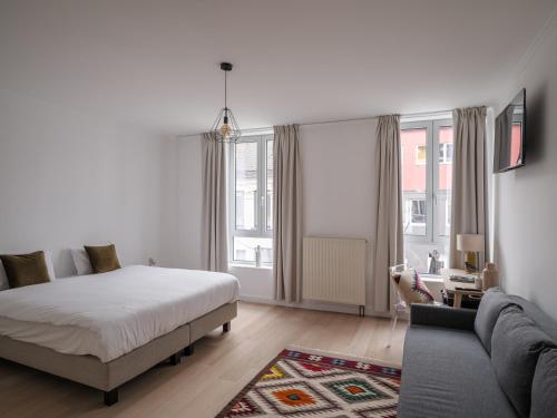 a white bedroom with a bed and a couch at Suzan's Guesthouse in Ghent