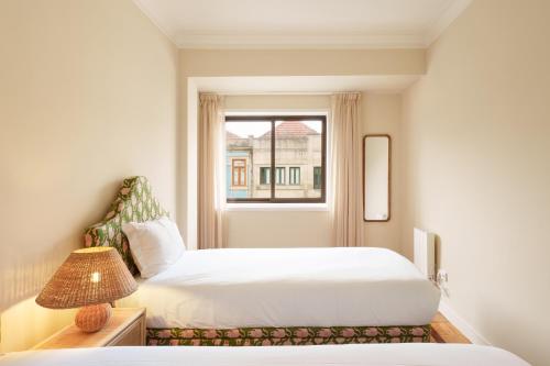 a hotel room with a bed and a window at VIVA Serpa Pinto Serviced Apartments in Porto