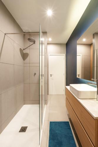 a bathroom with a glass shower and a sink at VIVA Serpa Pinto Serviced Apartments in Porto