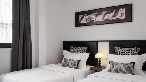 two beds sitting next to each other in a room at CASA BLANCA Dusit in Dusit