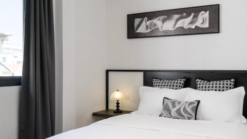 a bedroom with a white bed and a window at CASA BLANCA Dusit in Dusit
