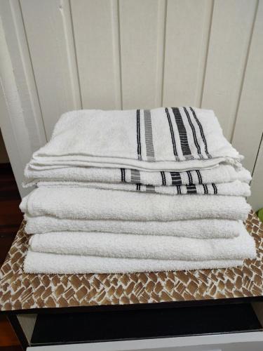 a stack of towels sitting on top of a table at Um lar acolhedor in Pato Branco