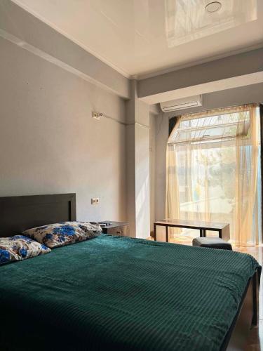 a bedroom with a green bed and a window at Saburtalo Central in Tbilisi City