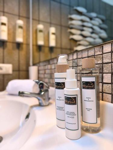 two bottles ofodorizers sitting on a bathroom sink at Spartaco Eco Retreat San Pantaleo in San Pantaleo