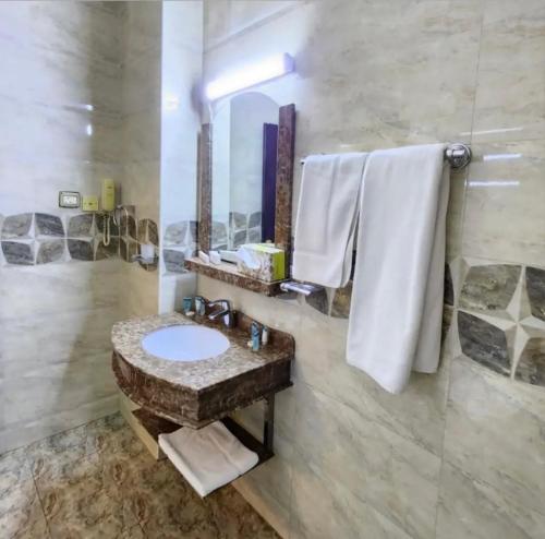a bathroom with a sink and a mirror at Muscat Horizon Hotel in Mawāliḩ