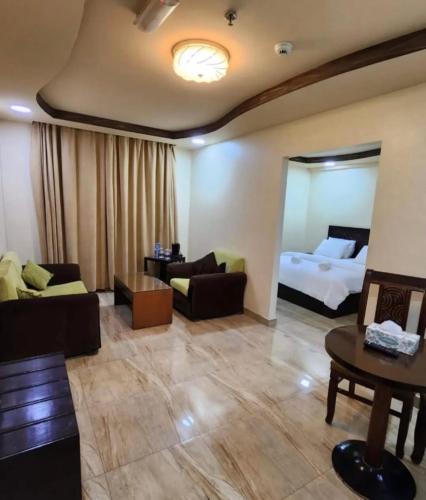 a living room with a bed and a couch at Muscat Horizon Hotel in Mawāliḩ