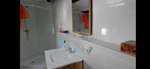 a white bathroom with a sink and a mirror at Can Manuel in Gabet