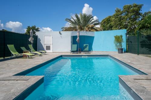 a swimming pool with blue water in a backyard at Villa Sibaloma in Saint-François