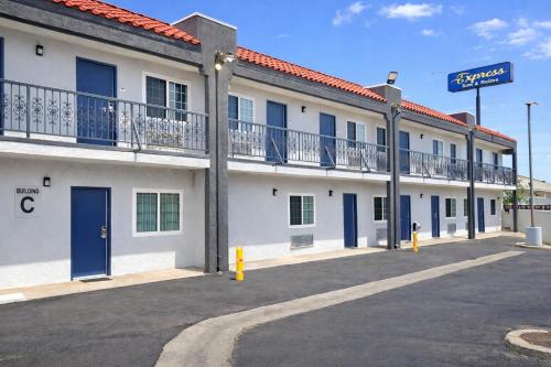 a large white building with blue doors and balconies at Express Inn & Suites Ontario Airport in Ontario