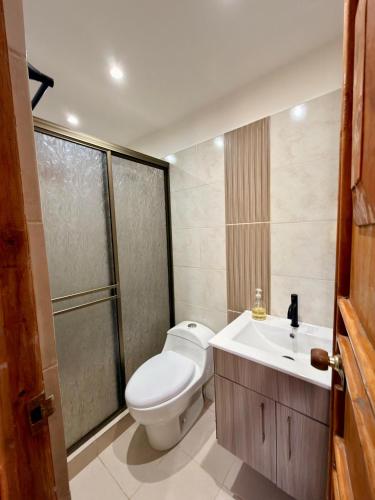 a bathroom with a toilet and a sink at La orquídea campestre in Montenegro